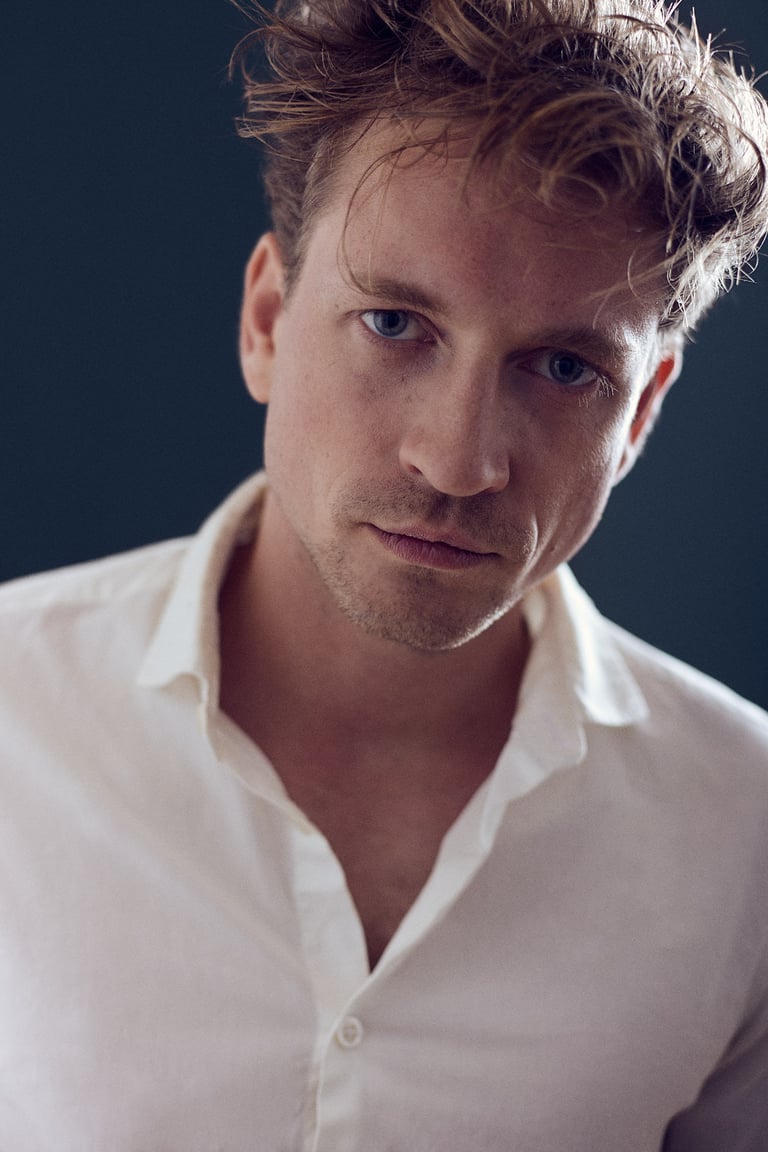 A portrait of a young man in a white shirt.