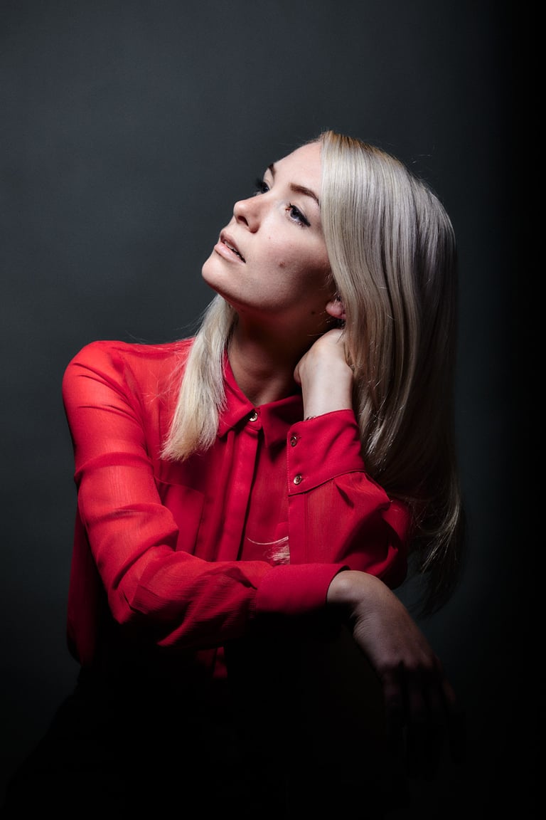 Blonde woman wearing a red blouse.