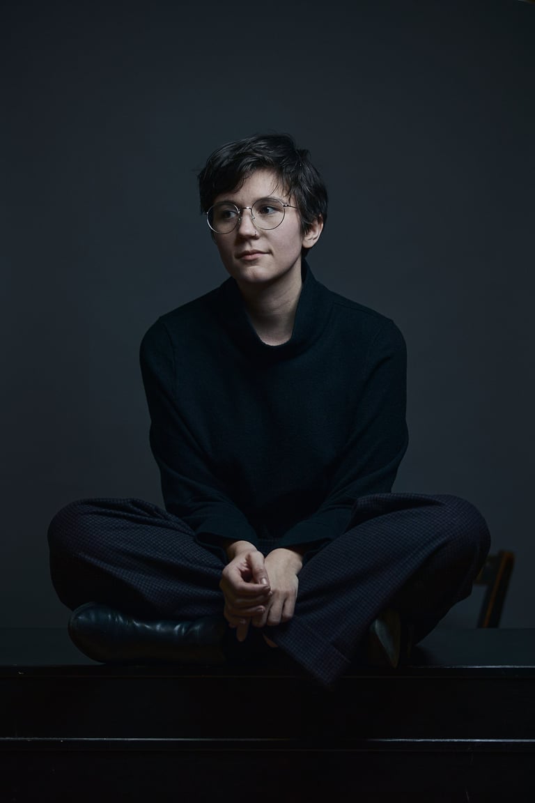 Miku Sophie Kühmel sitzt mit gekreuzten Beinen auf einem Tisch.