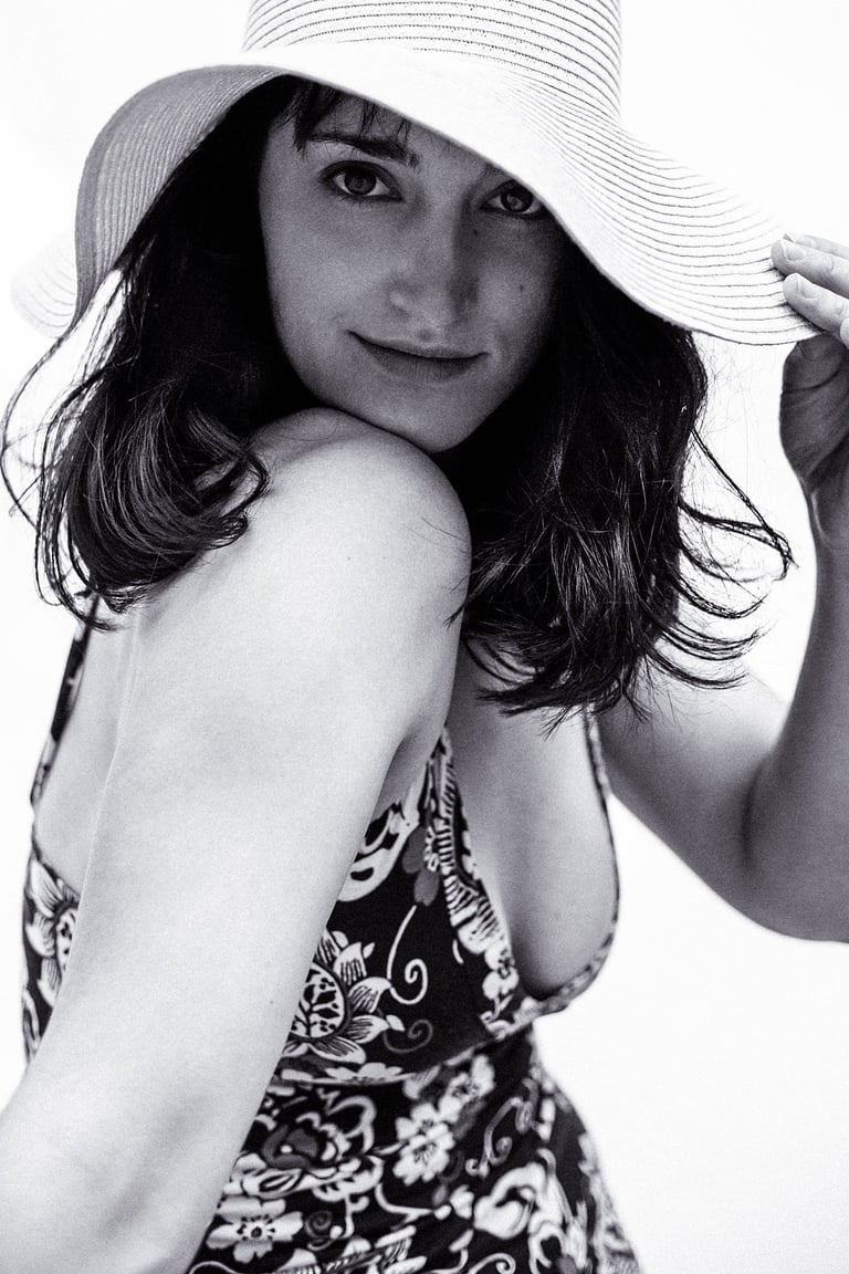 A young woman with a plunging neckline dress and a straw hat.