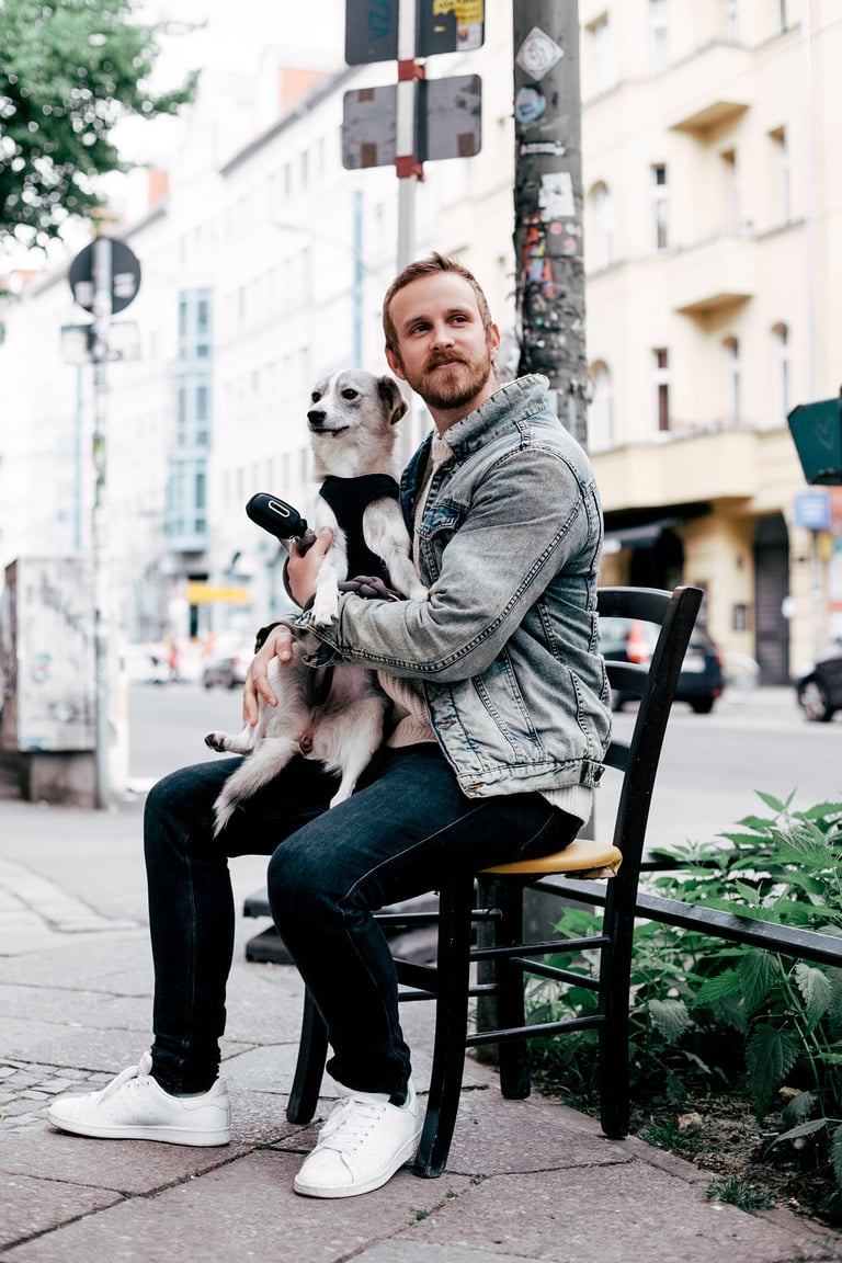 Steve Devonas sitting on a chair outdoors with his dog.