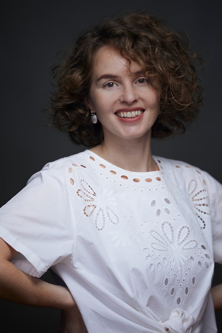 A portrait of a happy young woman in a white shirt.