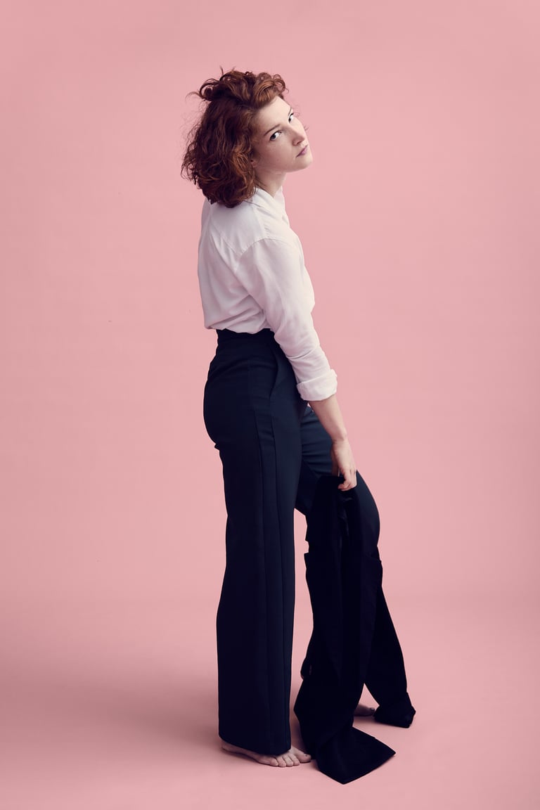 A woman wearing a white shirt and dark pants.