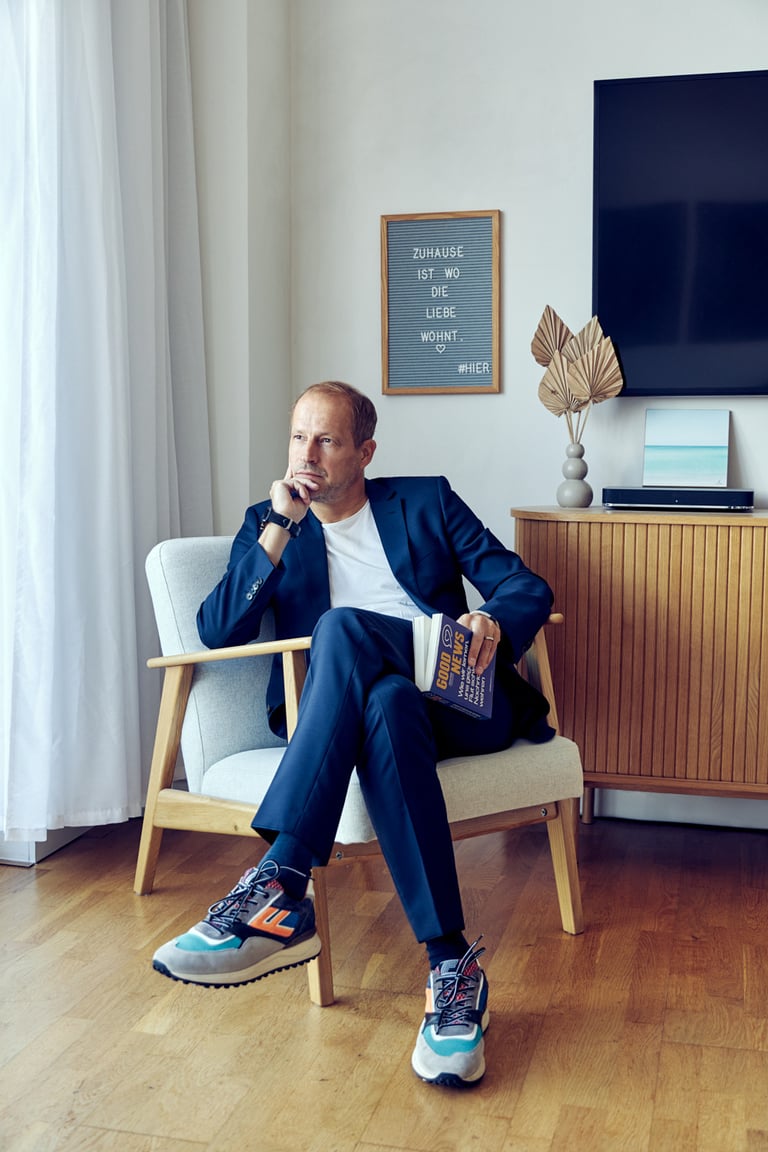 Tim Nidernolte sitting on a chair holding a book.