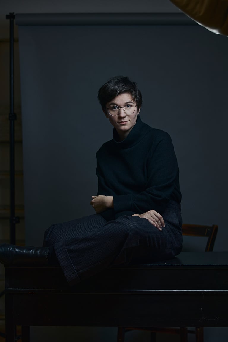 Eine junge Frau trägt einen Rollkragenpullover in einem Fotostudio.