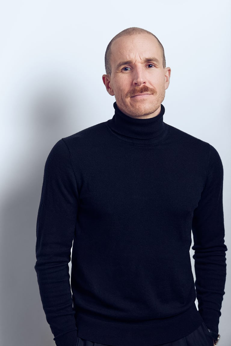 Porträt eines Mannes mit Schnurrbart in einem Atelier.