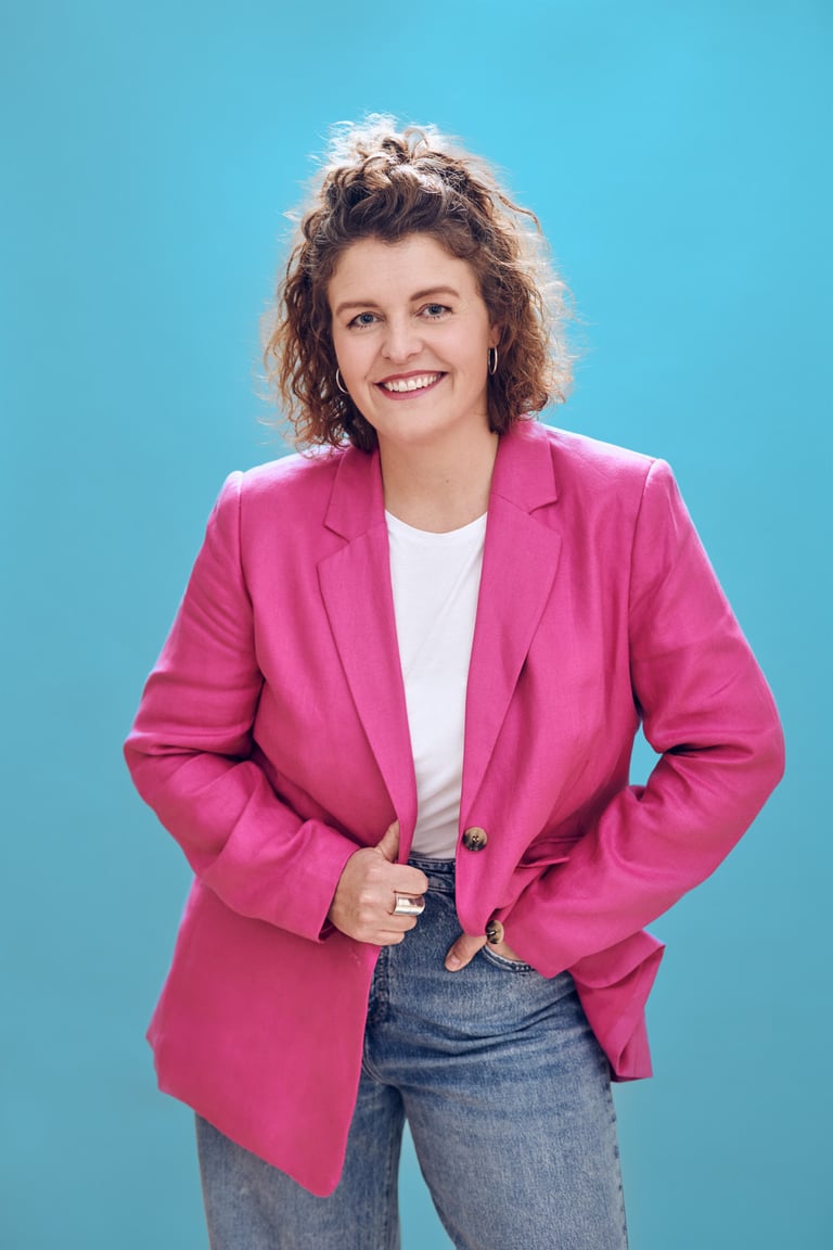 Woman with a pink jacket photographed on a blue background.