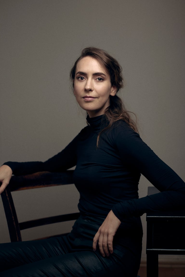 A woman sitting on a chair in a photo studio.