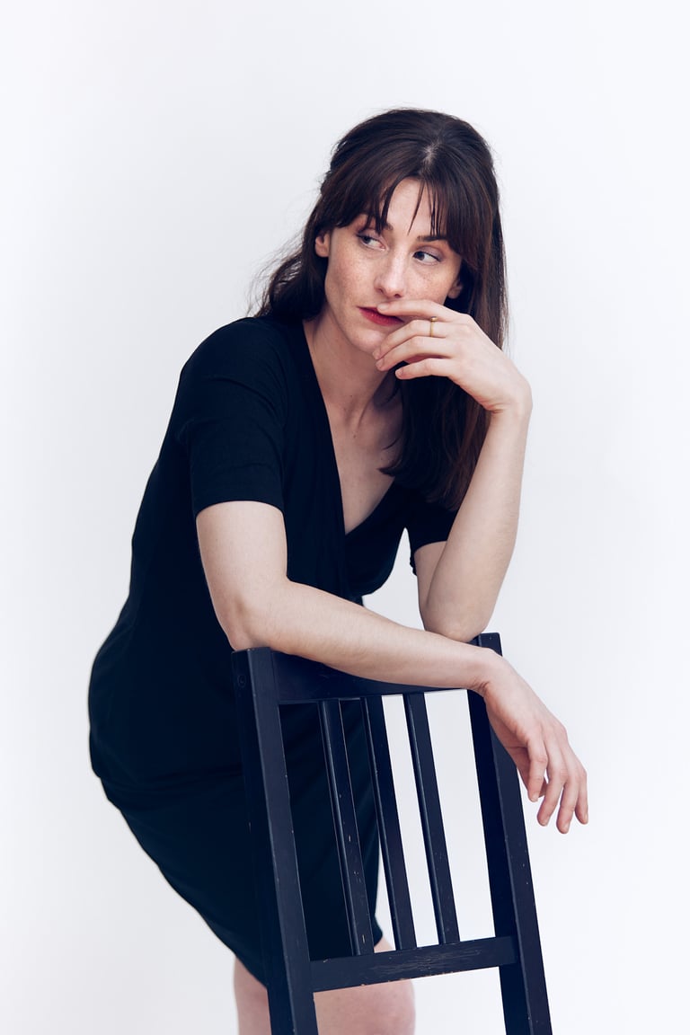 Woman looking to the side in a black dress.