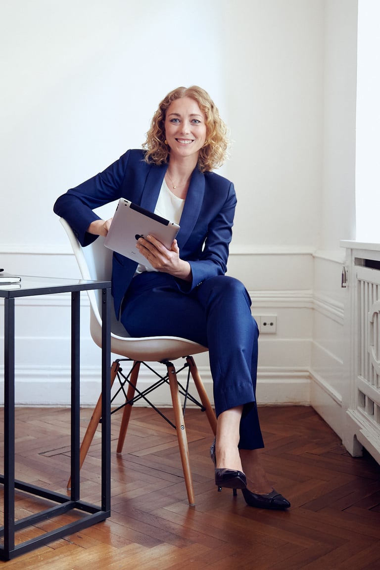 Woman holding an ipad sitting in an office.