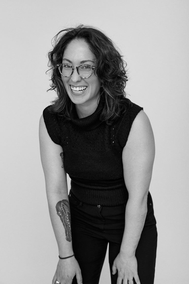 A black and white portrait of a woman laughing.