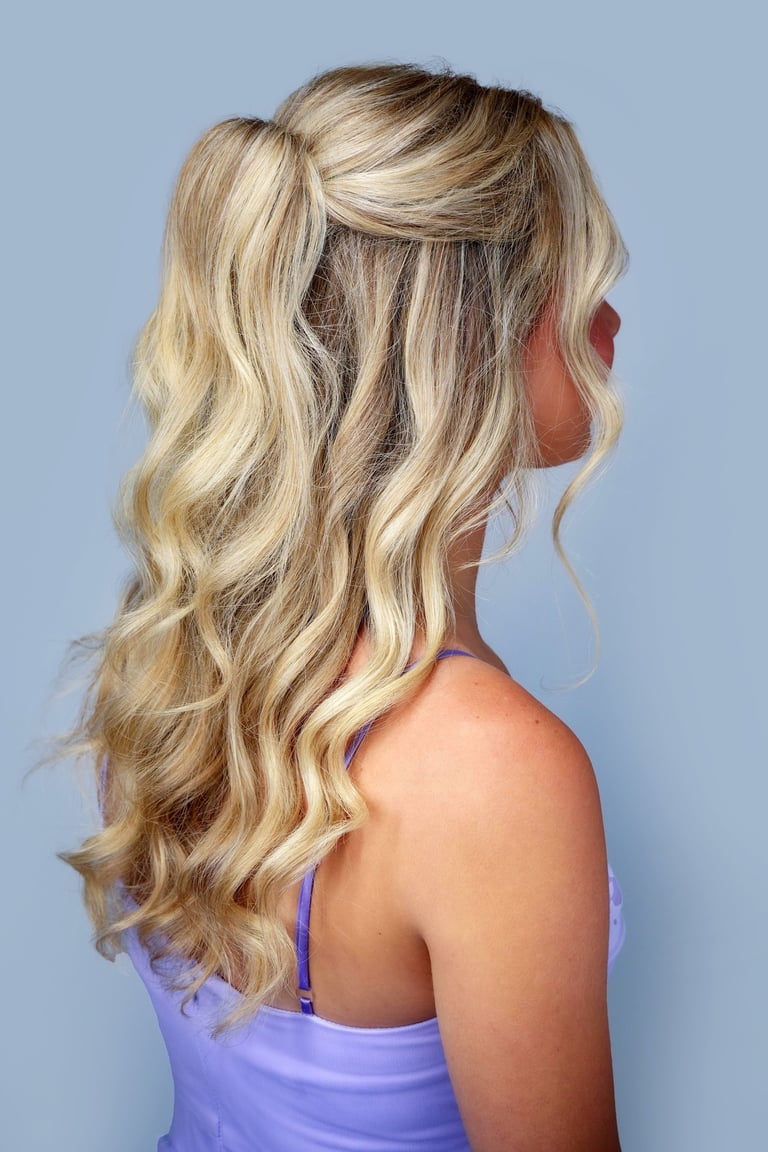 Bride with blonde hair styled in half-up glam waves, polished curls, and volume, perfect for wedding hair and makeup.