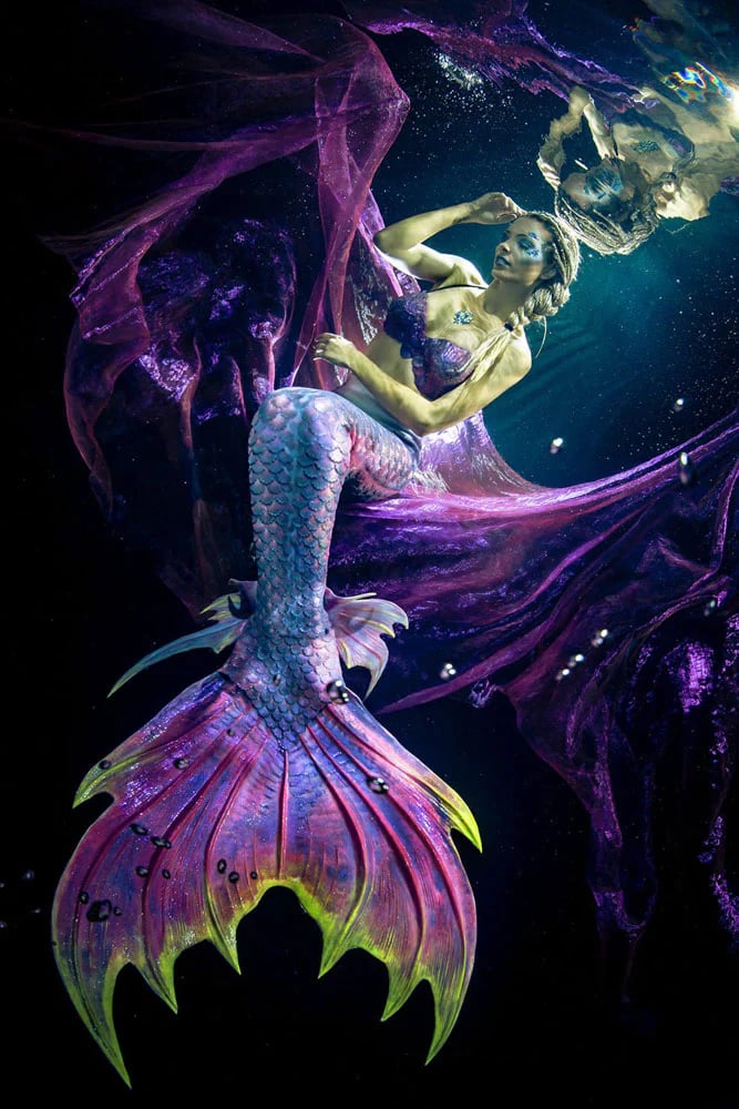 A dark purple and neon green tail by Mermaid Kat with multi colored ankle fins.