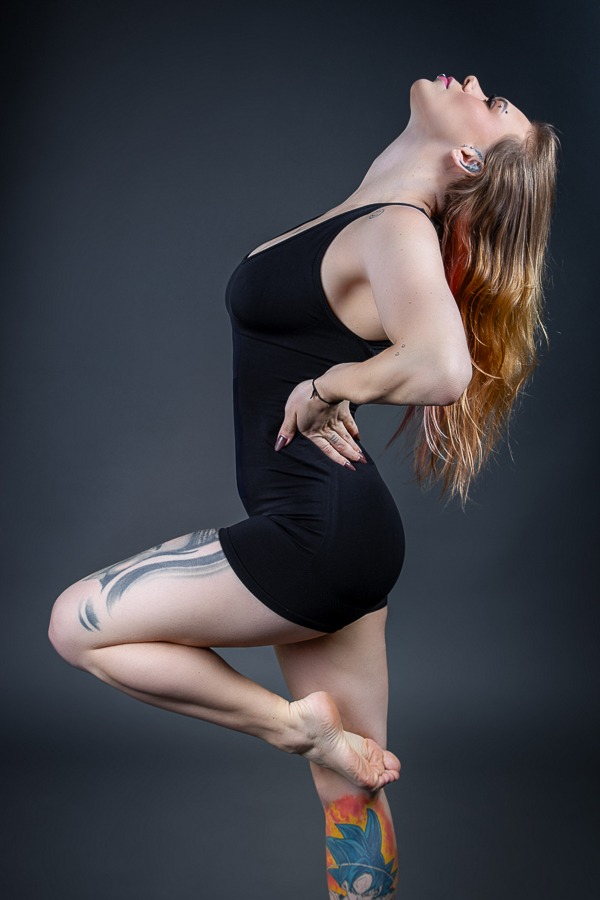 dançarina tatuada em pose artística olhando pra cima com cabelos jogados