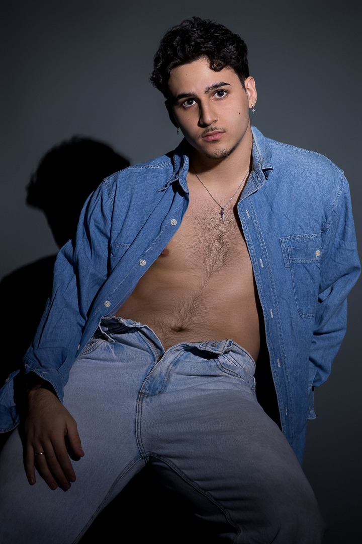 modelo masculino posando de camisa aberta em ensaio fotográfico em estúdio