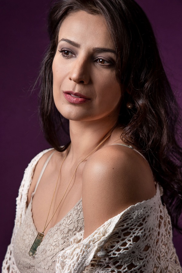 retrato atriz mulher branca olhando no horizonte , cabelo ondulado em fundo roxo