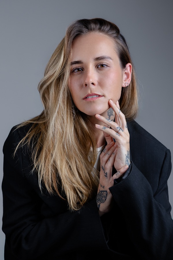 Modelo loira em esnaio fotográfico em estúdio fundo cinza