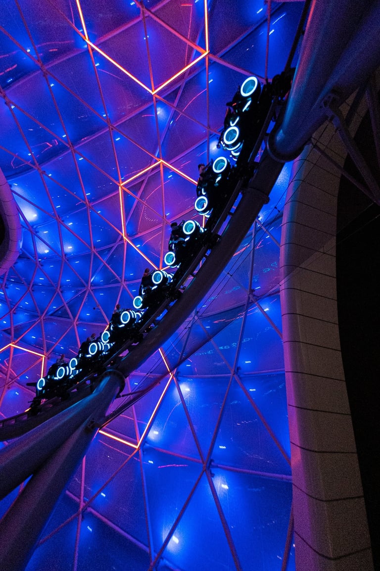 a roller coaster with a blue lit canopy background