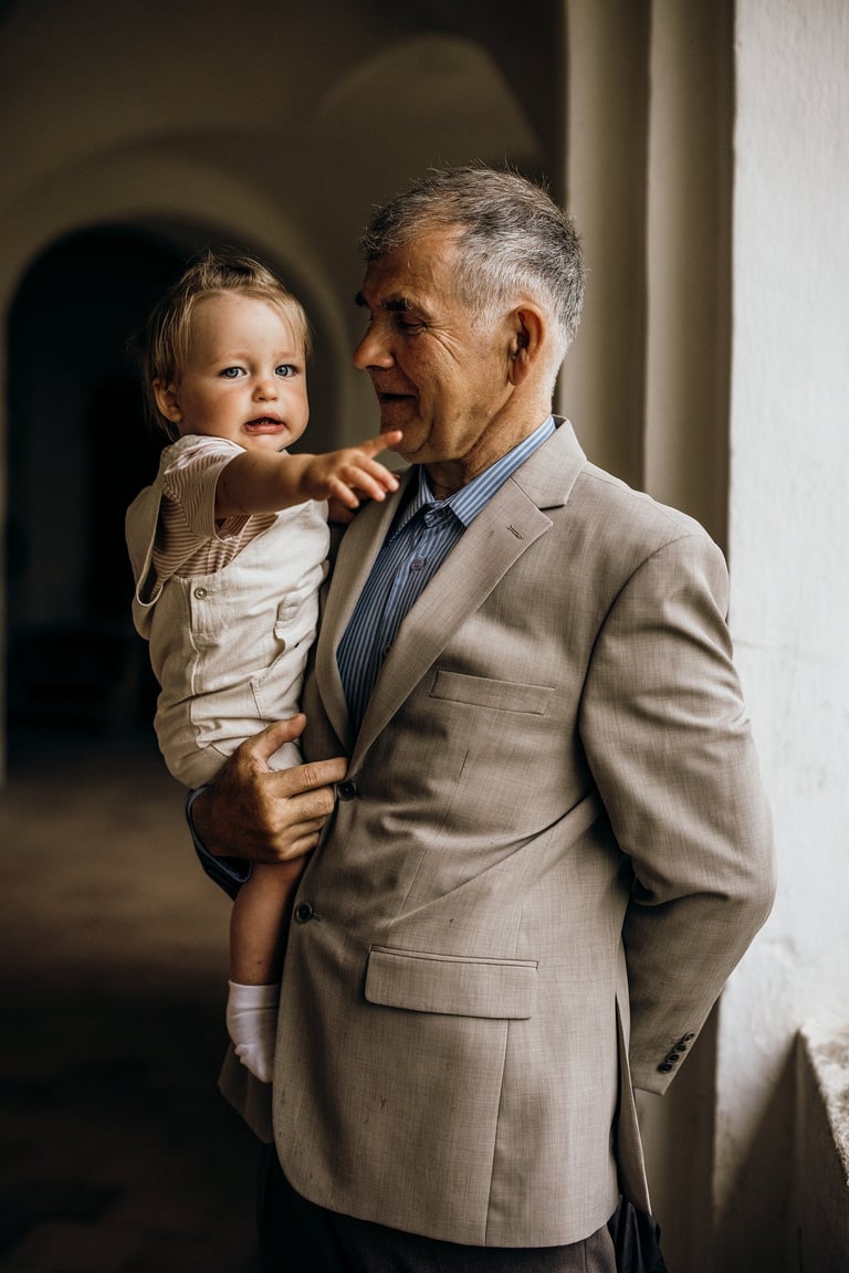 Krikštynų fotografija - senelis snt rankų laiko savo anūką