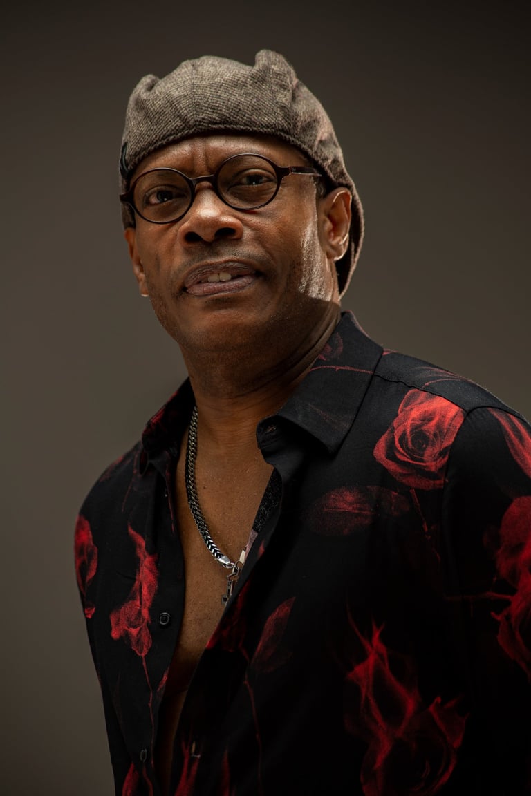 a man in a hat and glasses is smiling