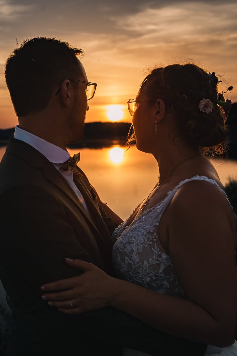 Photo d'un couple de mariés au coucher du soleil