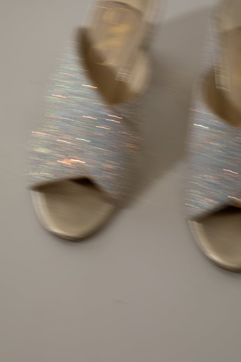 a pair of shoes with a silver colored shoelaced on them