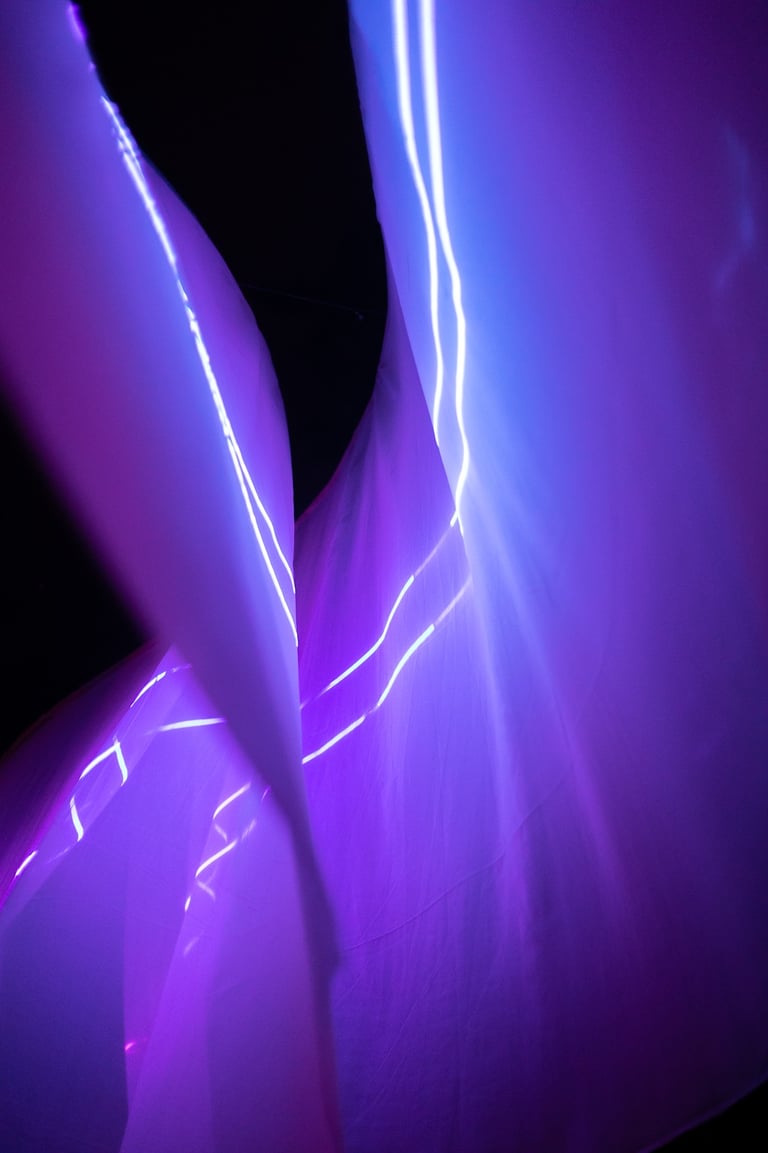 a person holding a knife and knife in front of a purple light