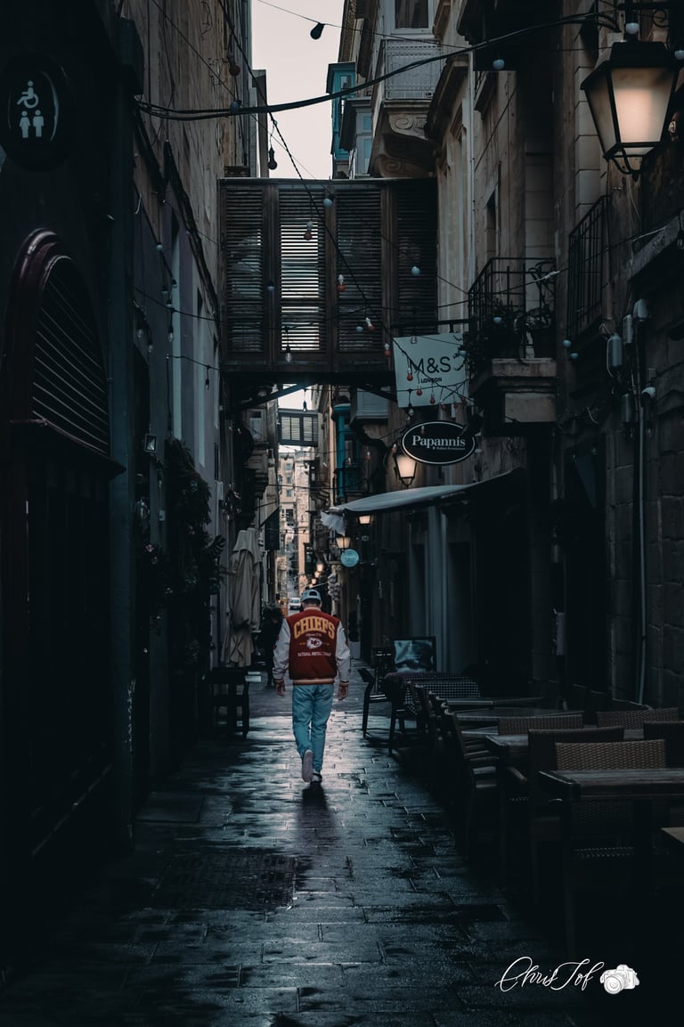Photos de rue , street , d'un homme marchant dans une ruelle sombre et contrastée de Malte