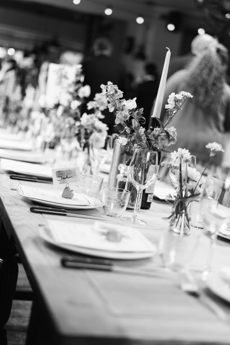 black and white image of a wedding table with candles and flowers