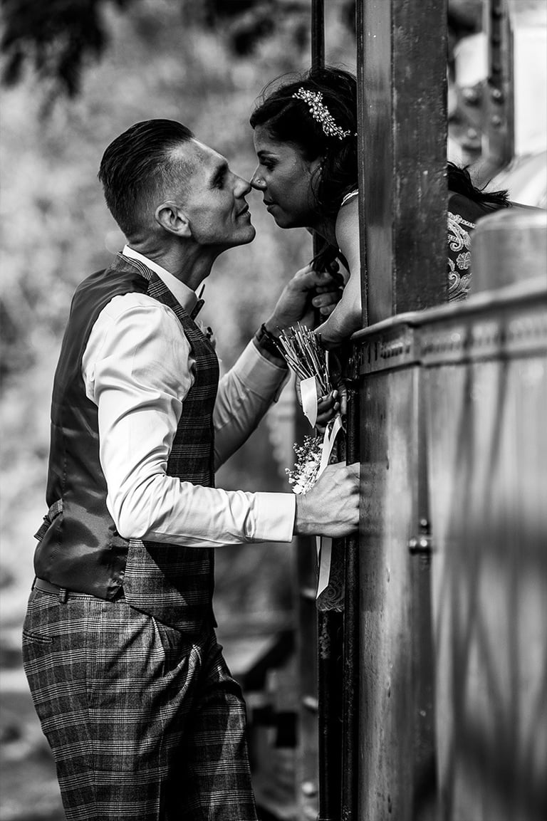 Marié regarde amoureusement sa mariée à la fenêtre de vieux train.