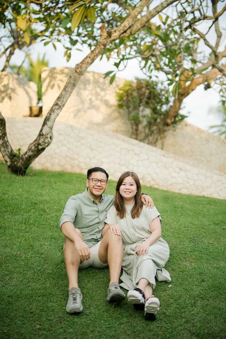 Couple sitting together in a tropical garden during a family photography session in Bali.