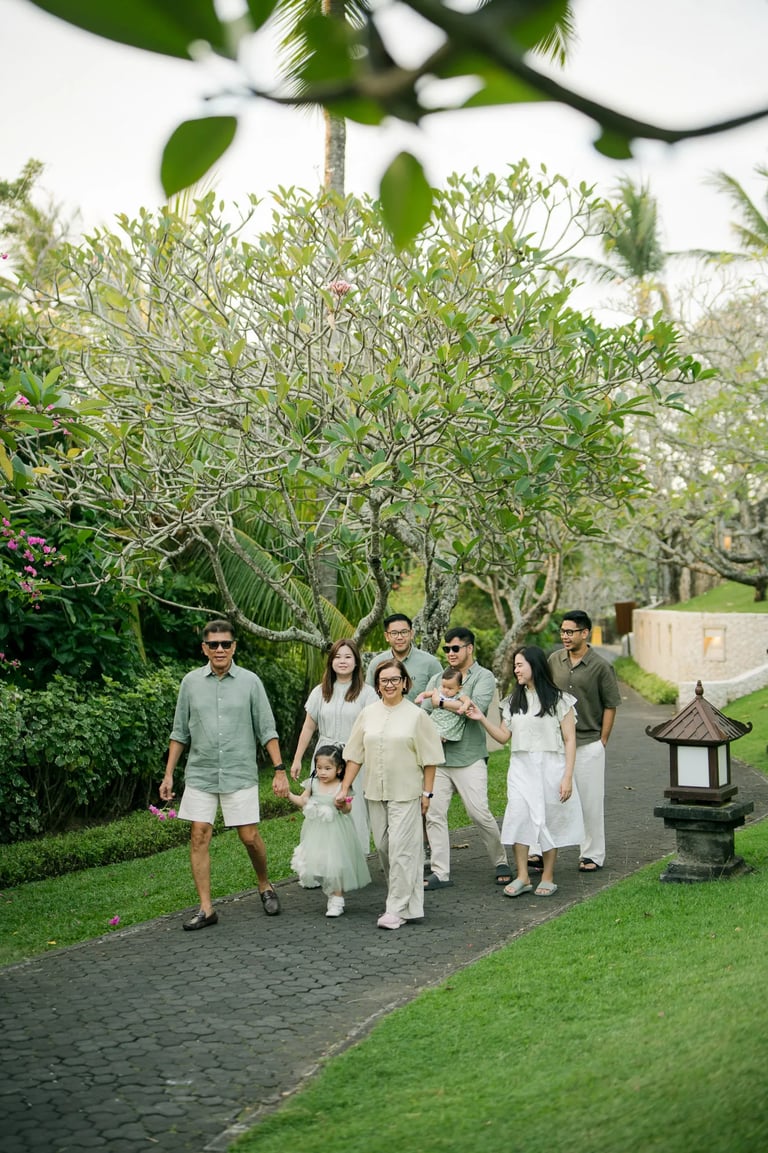 Extended family standing together on a resort garden pathway during a multigenerational family photography session in Bali.