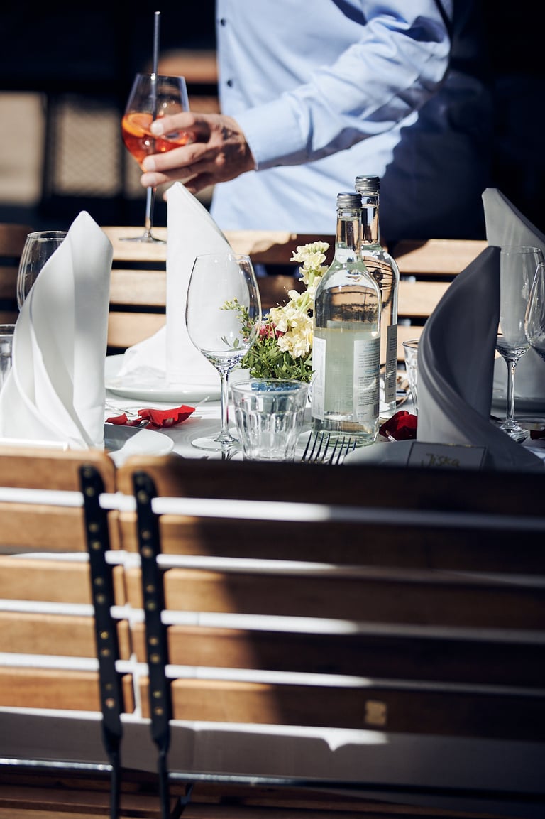 A wedding guest walking past a table holding an Aperol Spritz.