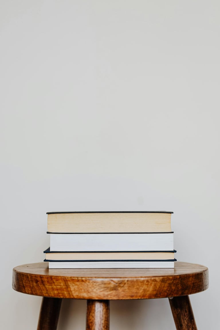 wooden stool with a pile of books on top