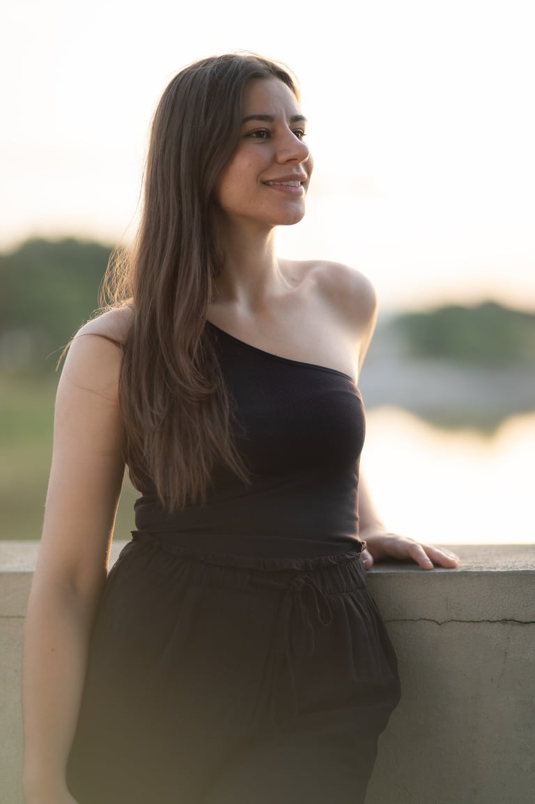 a woman in a black dress standing on a ledge