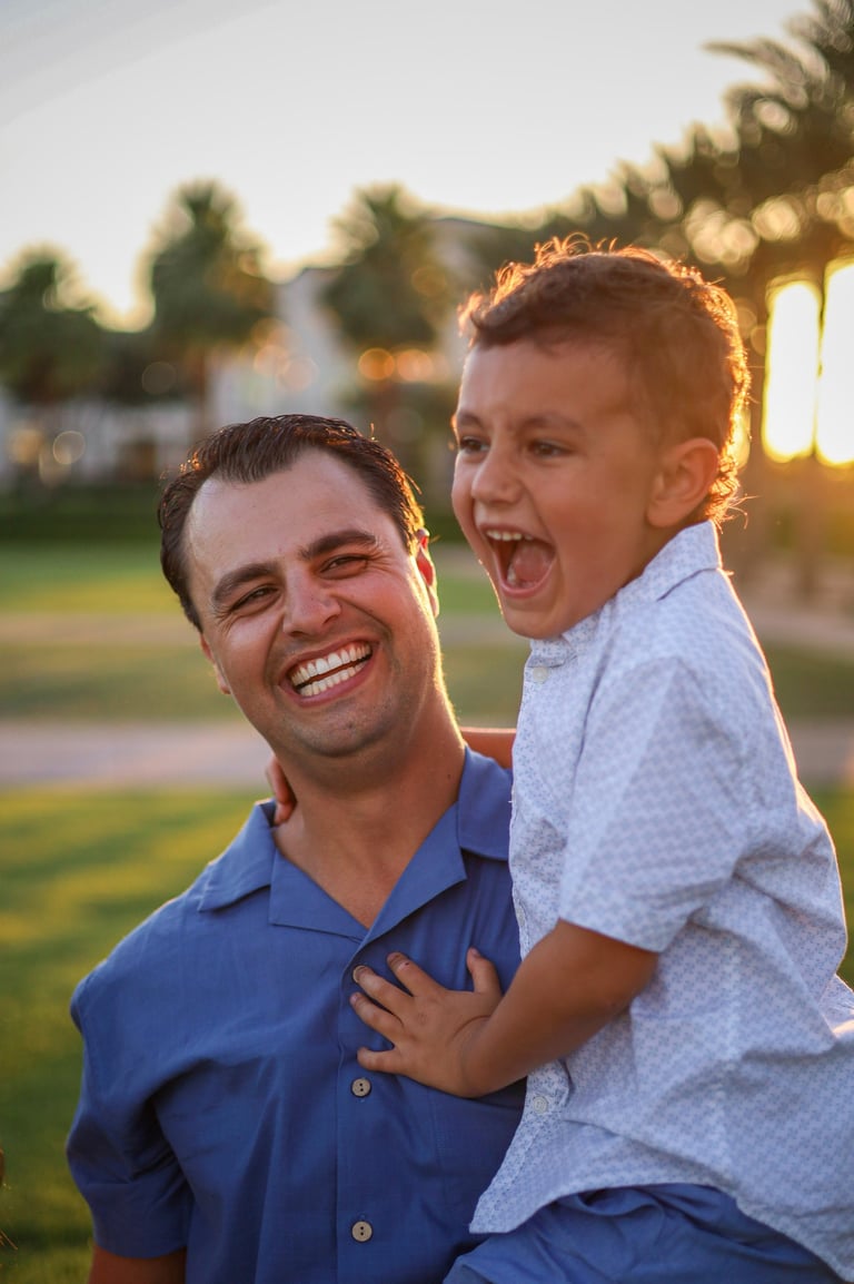 Father and son laughing together during an outdoor family photography session in Arizona.
