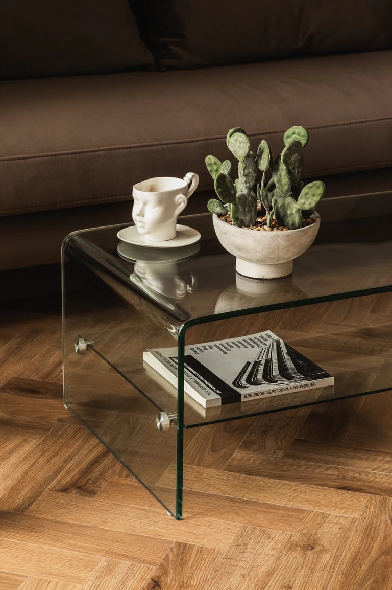 Sesja wnętrzarska: szklany stolik kawowy i dekoracje w salonie. Profesjonalne zdjęcia wnętrz.