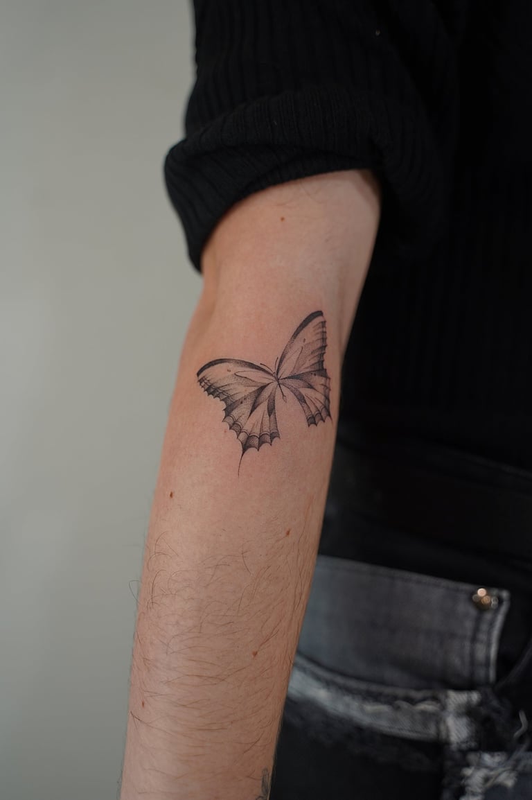 Tatuaje fineline en Madrid de mariposa con alas simétricas y detalle de venas en trazo fino madrid