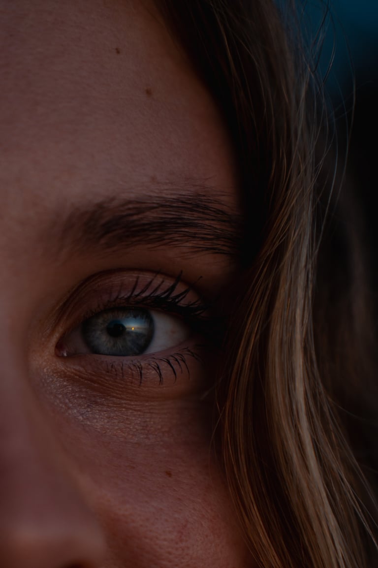 a woman with blue eyes and a toothbrush in her mouth