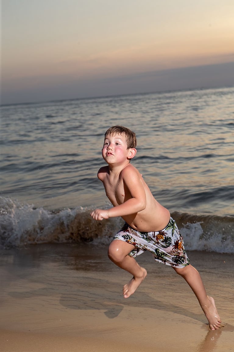 Ребенок бегает по пляжу на Фукуоке