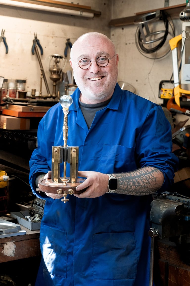 Mains de Yann Franconie, artisan fabricant de luminaires présentant une lampe dans son atelier