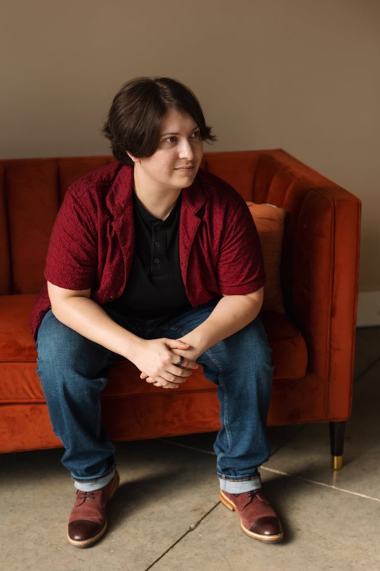 Photo of Rashad McAllister sitting on a couch and listening to someone off camera