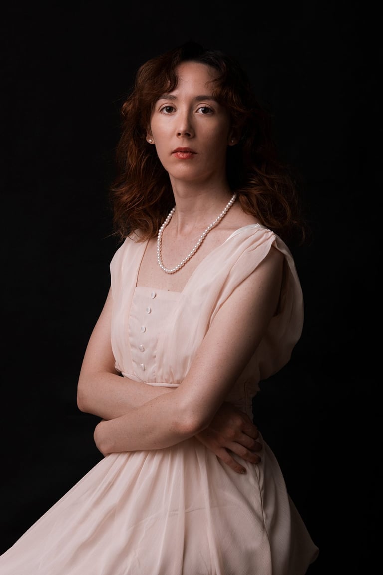 a woman in a white dress and pearls necklaces