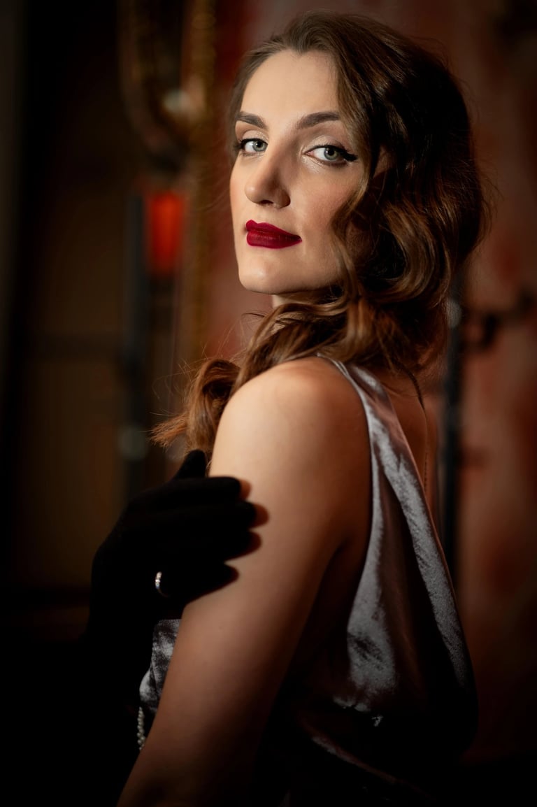 Striking old hollywood style portrait photo of a woman with red lipstick, silver dress and gloves