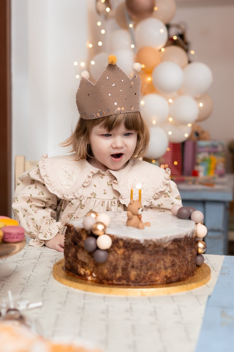 mala djevojčica koja puše svijeće na torti