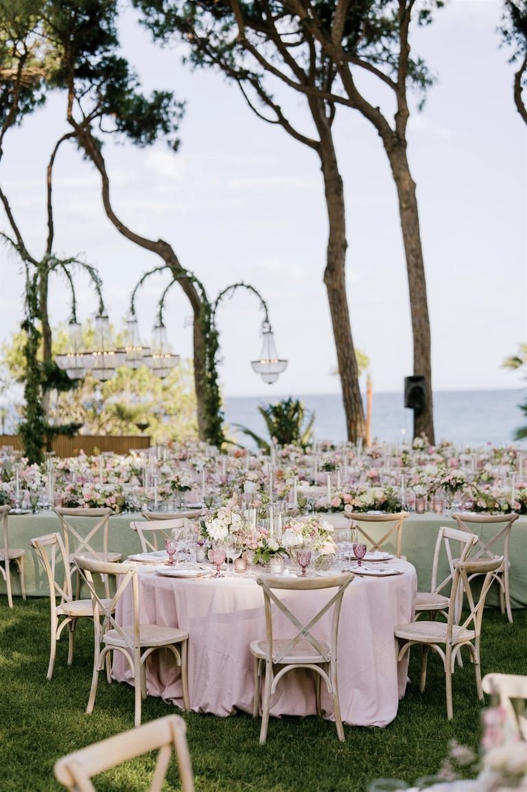 Seafront garden event layout with chandeliers and banquet tables