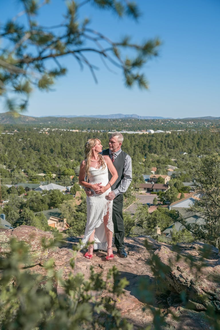 a man and woman standing on a mountain top