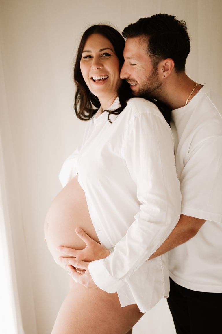 matenrigy couple photo holding baby bump, taken in studio Littlehampton