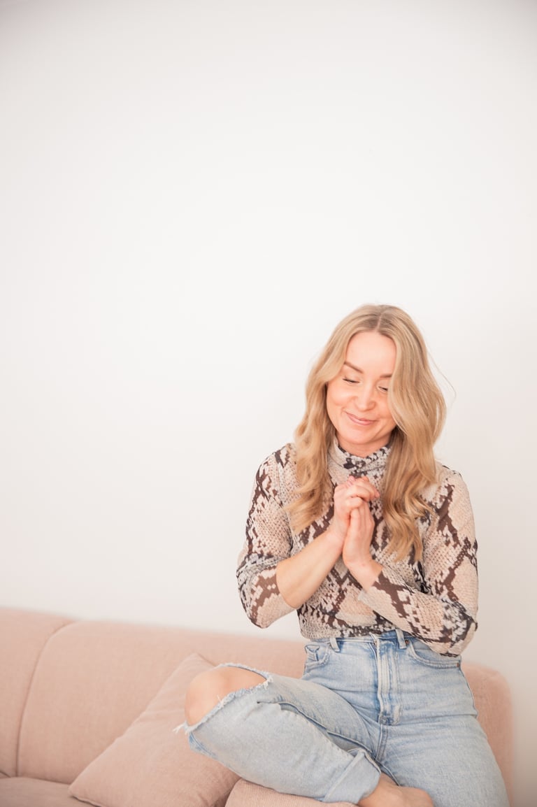 Saija Uussaari sitting on a couch with her hands clasped together