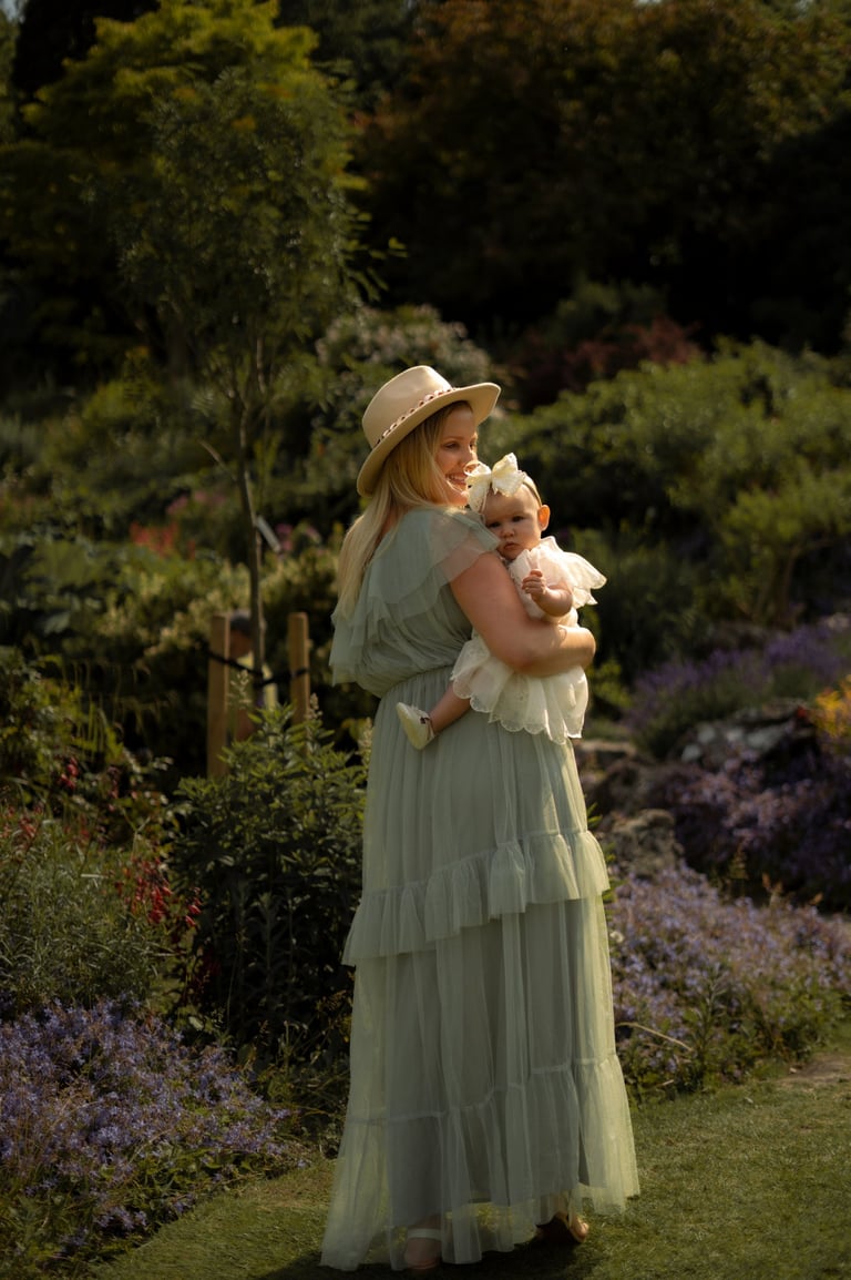 mother holding her baby on the arms in the park